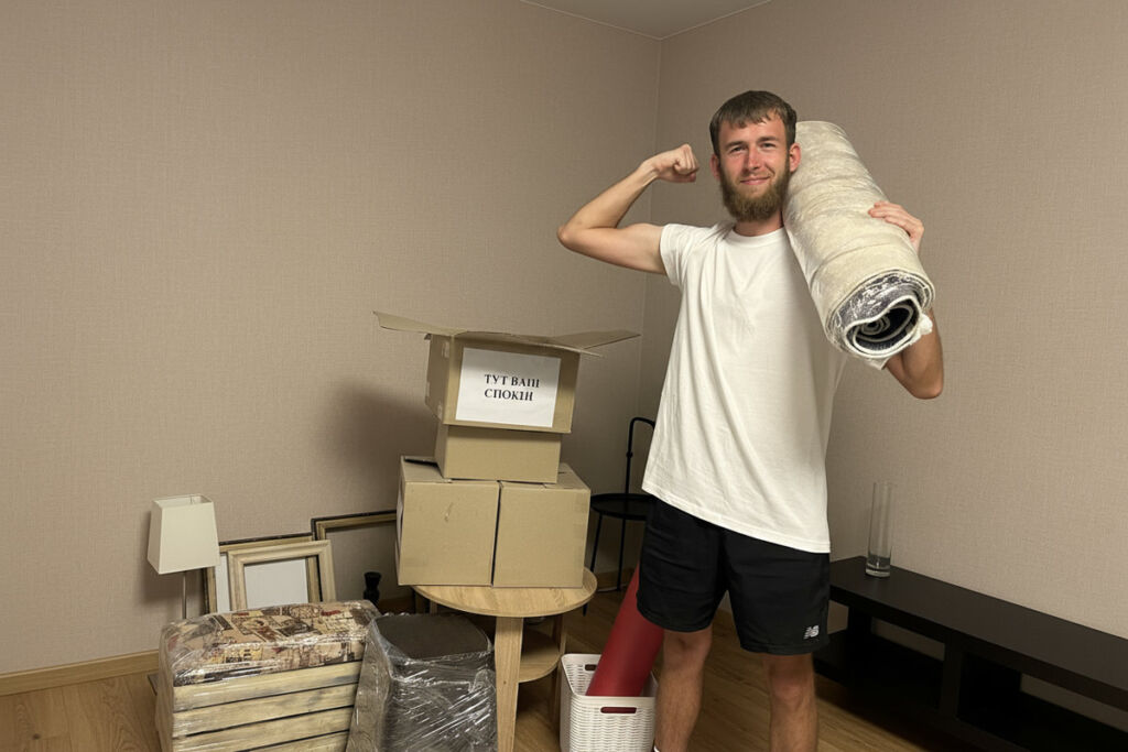 Вантажник несе коробки з речами, квартирний переїзд