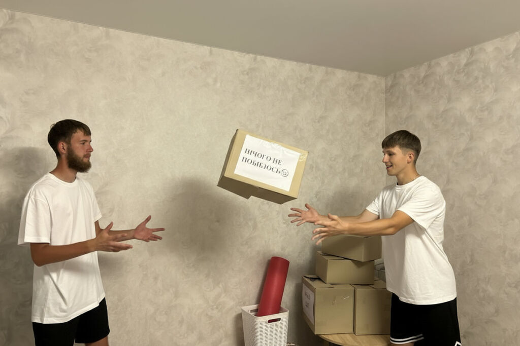 Вантажники обережно переносять габаритні меблі під час переїзду